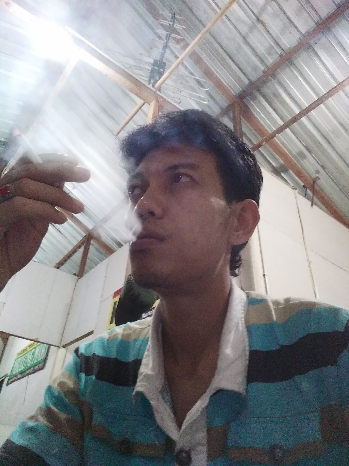 Cowok keren lagi santai menikmati segelas kopi dan rokok 