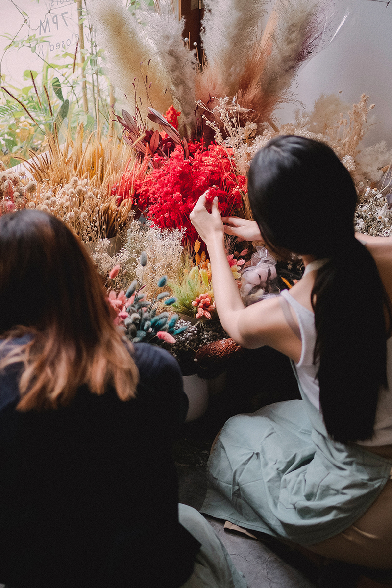 two women florists arranging flowers in a flower store