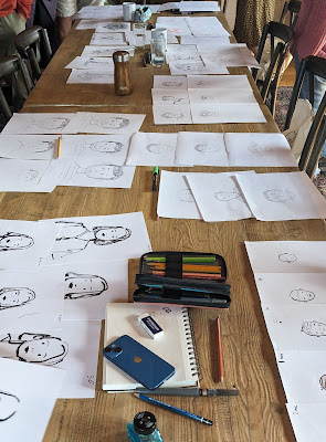 A table covered with sketches of self-portraits