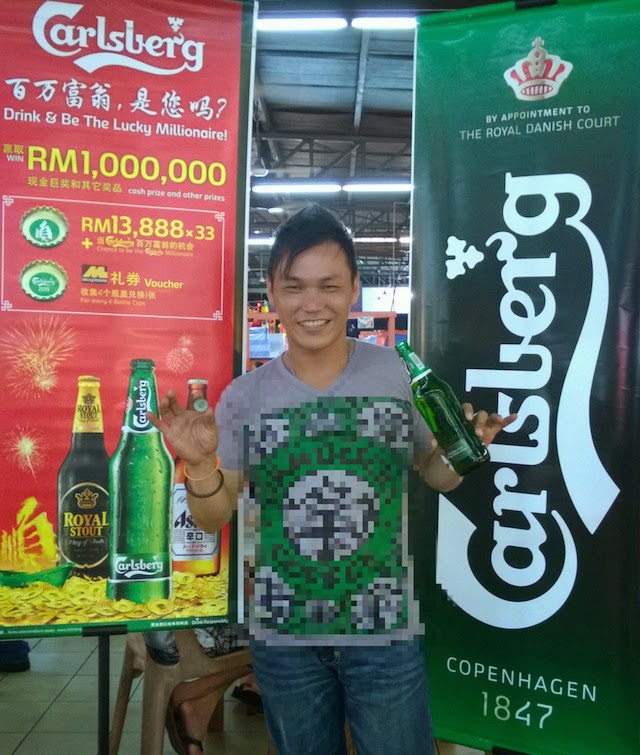 Wong See Min gives us his biggest smile as he displays a large bottle of Carlsberg and the bottle cap which put him in the running to become the 'Carlsberg Millionaire'