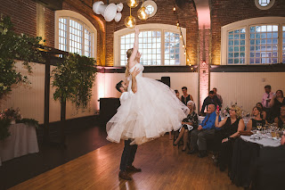 groom lifts bride during first dance at the evergreen