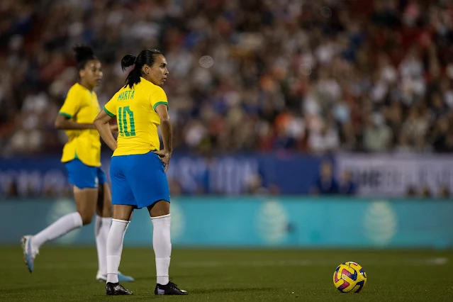 Marta parada com a camisa 10 amarela, esperando para cobrar falta