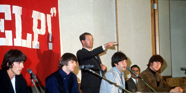 The Beatles en conferencia de prensa en Capitol Tower, donde el presidente de Capitol Records, Alan Livingston, les presenta discos de oro el 29 de agosto de 1965, en Los Ángeles, CA