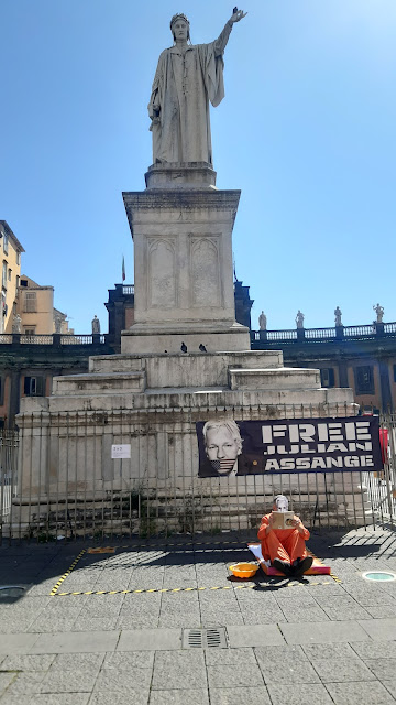 l'attivista che impersona Assange nella cella in isolamento. Sullo sfondo la statua di Dante