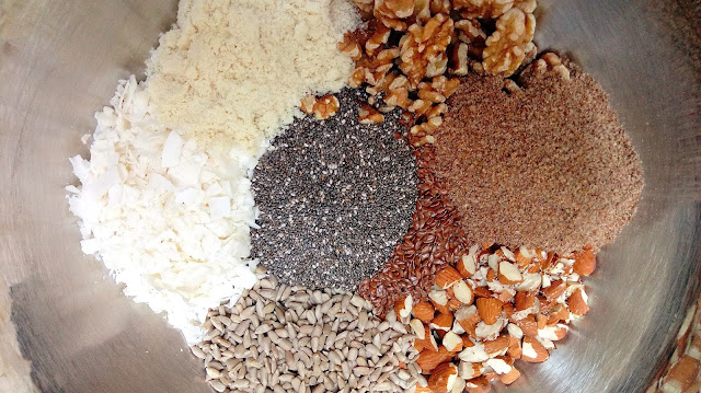 a large stainless steel bowl full of nuts, seeds, and coconut for Grain Free Granola