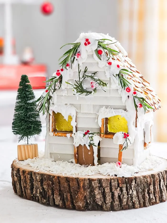 white shiplap gingerbread cottage, candy windows, frosting snow