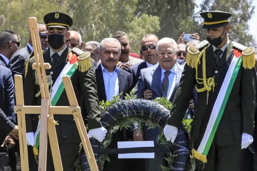 O líder palestino Mahmoud Abbas (à direita) e o primeiro-ministro Mohammad Shtayyeh (à esquerda) prestam homenagem aos palestinos falecidos nos recentes ataques militares israelenses, depositando uma coroa de flores junto aos túmulos no campo de Jenin, na Cisjordânia | Zain JAAFAR/AFP