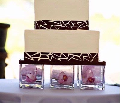 A unique idea incorporating glass vases and flowers to hold the wedding cake
