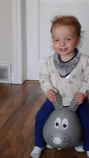 Aiden smiling, sitting on a bouncy bunny you.