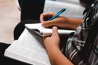 Hombre con cuaderno y lapicero estudiando la Biblia