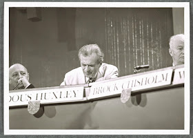 A photograph of three men seated at a panel.