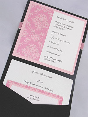 A pretty invitation with black and pink embellishments and a pocket within