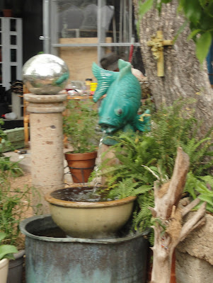 fountain made of junk, water coming from a fish sculpture