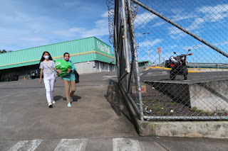 Two masked women in Maxi Pali parking lot, Puriscal