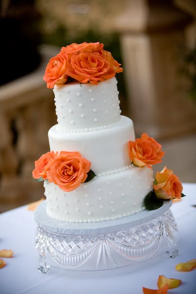 Three tier round wedding cake with fresh roses in burgundy 