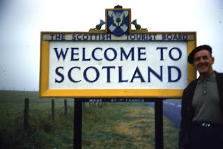 Charles standing in front of Welcome to Scotland sign