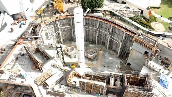 The first of two solid rocket motors that will form the backbone of Endeavour's completed space shuttle stack is lowered into the construction site for the Samuel Oschin Air and Space Center in Los Angeles...on November 7, 2023.