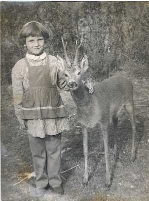 Fotografie alb-negru cu o fetiță și un cerb.