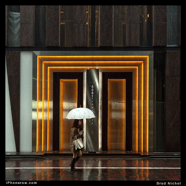 Ginza Laneway Japan with teeming rain and lady with umbrella during typhoon.