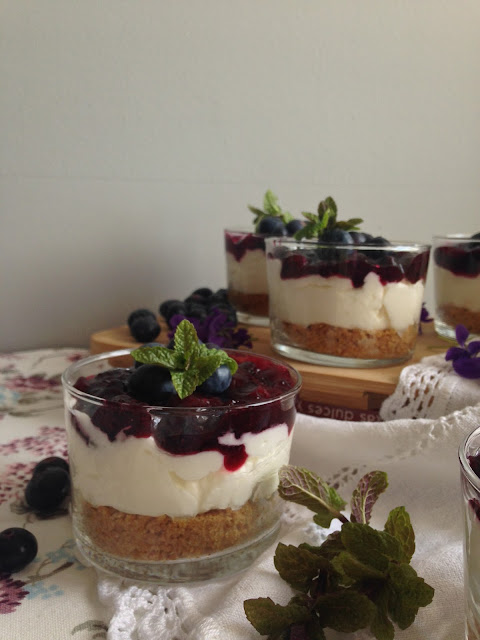 tarta de queso con mermelada de arandanos en vaso