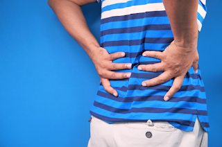 A man holding his lower back in pain | best chiropractor Ann Arbor