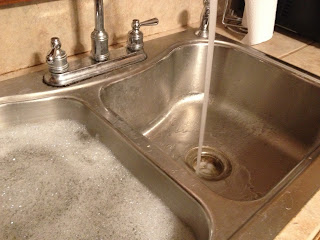 picture of my sink, left side filled with soapy water, right side empty with water running.