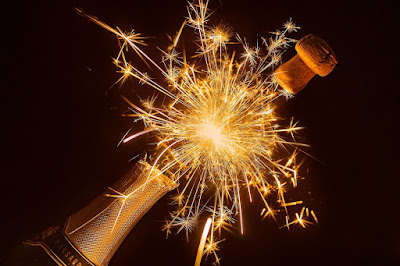 Champagne bottle fireworks on black background