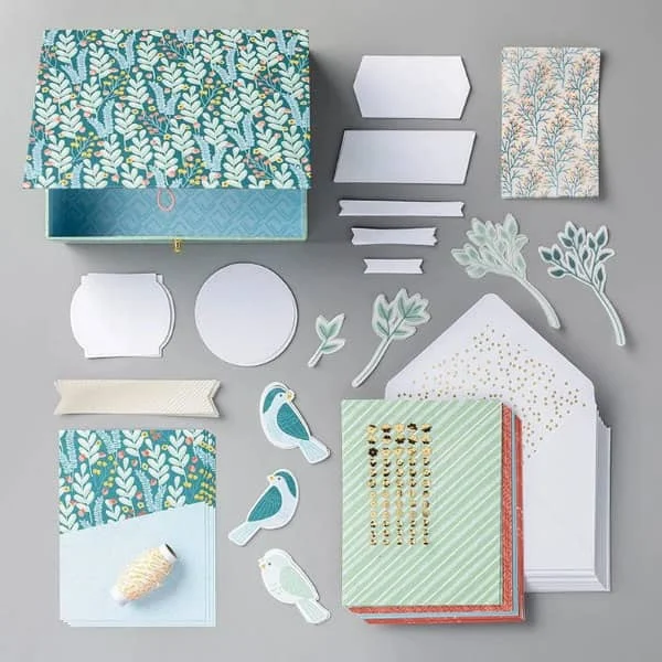 materials for cardmaking including papers, embellishments, paper birds and patterned paper box