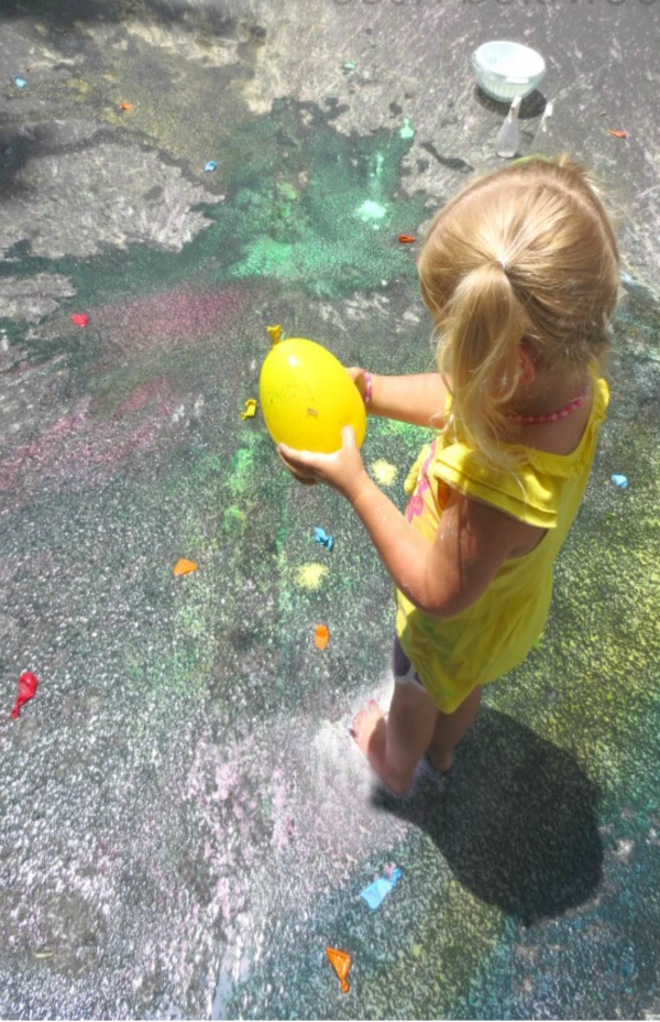 Make colorful rainbows all over the pavement using this easy chalk-filled balloon recipe for play. #chalkart #chalkpaint #chalkfilledballoons #chalkballoonsforkids #sidewalkpaintrecipe #growingajeweledrose #activitiesforkids