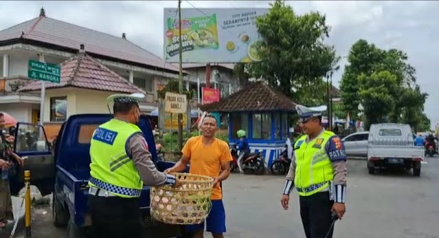 Anggota Satuan Lalu lintas Polres Bangli Bantu Pedagang angkat barang