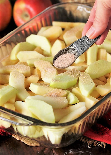 Sprinkling Cinnamon on Sliced Apples to Make Mom's Apple Crisp Image