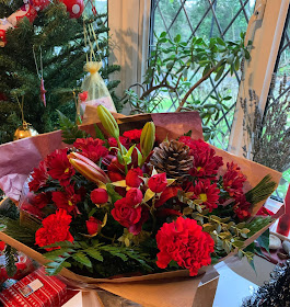 A bouquet of flowers in Christmas colours - red and gold. 
