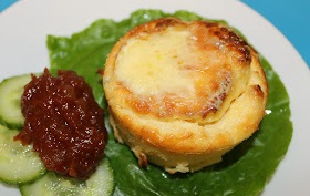 a mini twice baked cheese souffle served with salad and chutney
