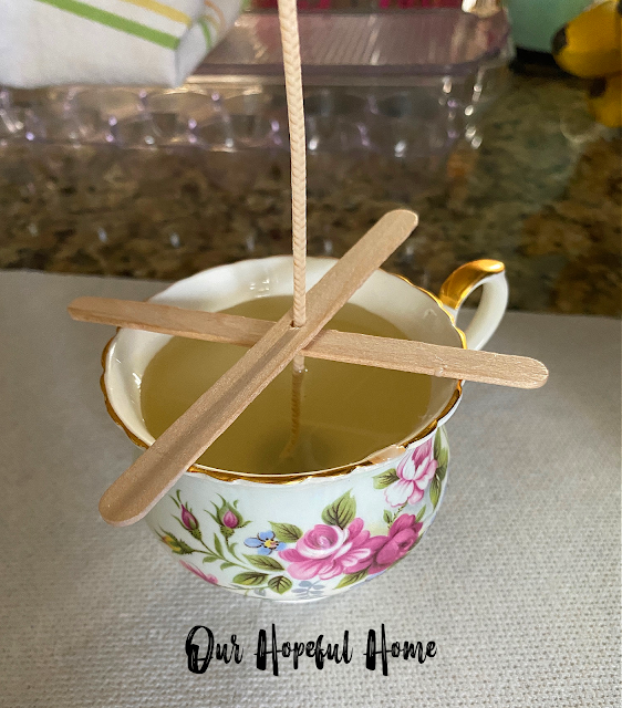 vintage rose tea cup DIY poured candle with melted wax and centering sticks