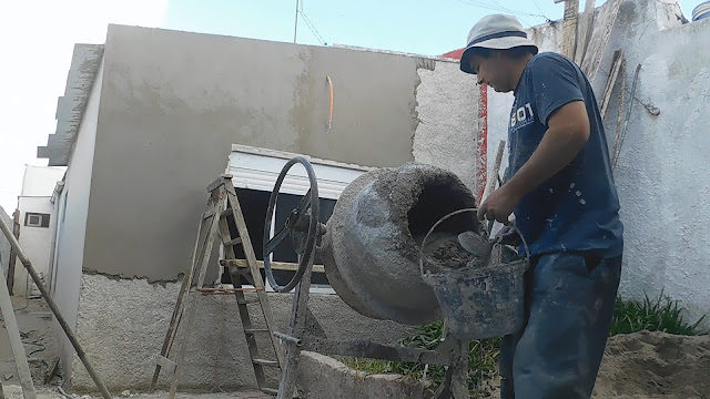 Un albañil prepara el mortero de cal y arena para revocar una pared.