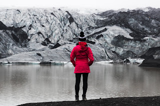 woman in pink looks at a snow covered mountain