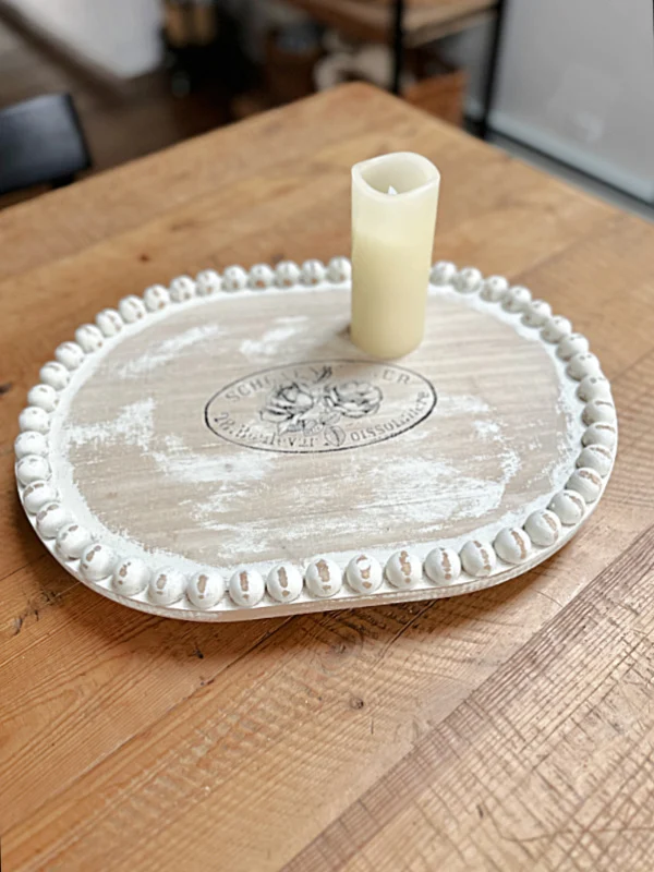 Distressed wooden tray with image and candle on table
