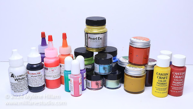 A selection of colourful resin pigments, dyes and mica powders sitting on a white tabletop