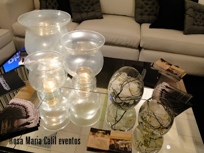 mesa centro espelhada, trio de velas em taças peroladas, almofadas pretas, almofadas prata, orquídeas brancas