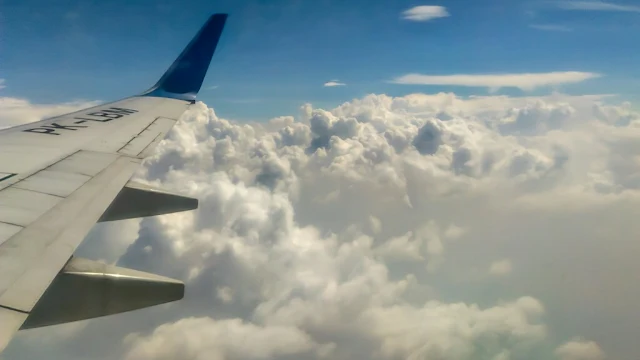 melihat awan di samping jendela pesawat