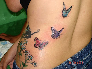 Uma fada e três borboletas tatuadas na parte lateral das costas