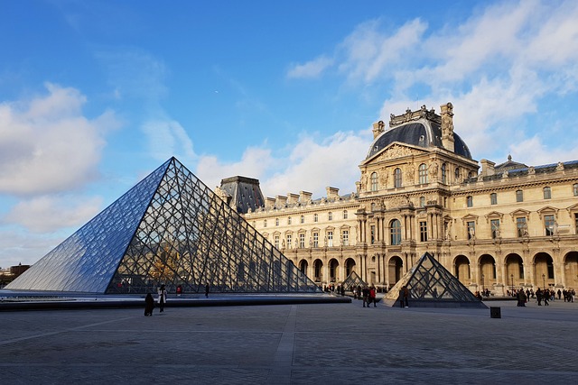 View of the Louvre Museum, showcasing its grand architecture and iconic glass pyramid. Visitors exploring the vast galleries filled with art and historical treasures.