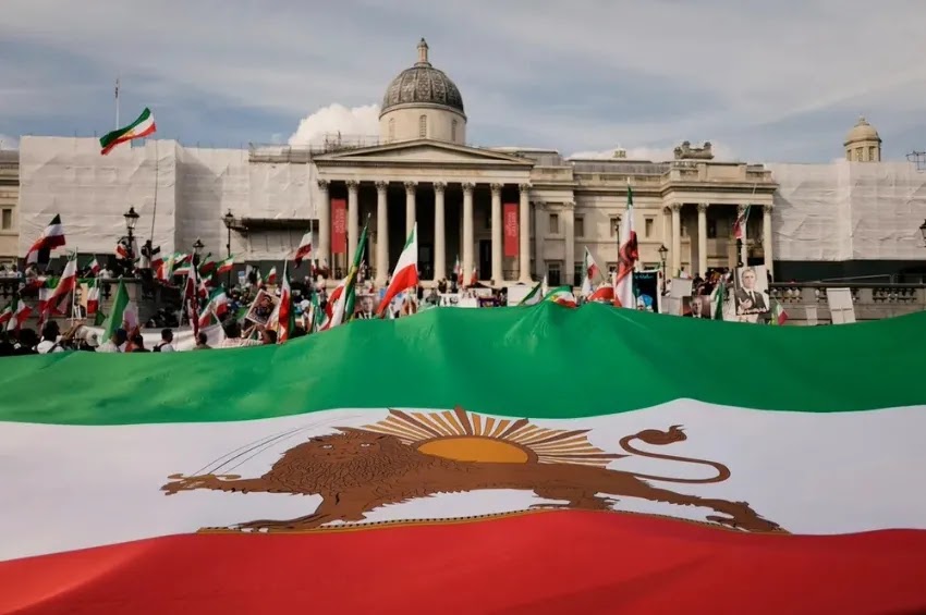 Manifestantes exibem uma bandeira iraniana gigante pré-revolução em Londres, Inglaterra | Foto AP/Alberto Pezzali
