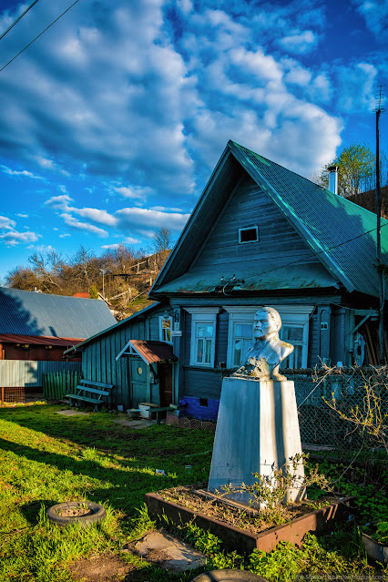 Бюст Ленина на фоне деревенского дома