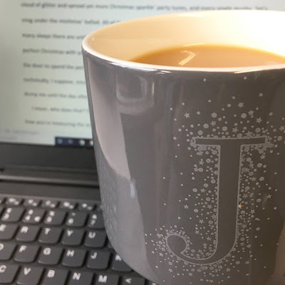 Grey mug in front of laptop