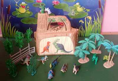 Brinquedo de plástico, estojo parque dos dinossauros que vira cenário, com árvores e cercado +   mini dinossauros, 6cm na média - fechado mede fechado 22cm de comprimento ;20cm de altura e 10cm de espessura - um dos pinos da parede maior que abre está faltando, não afeta o fechamento do estojo - 50,00