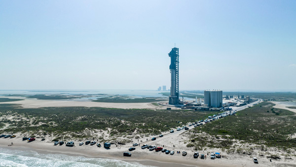 A crowd of onlookers gather at Boca Chica Beach to check out Starship Super Heavy as it stands tall on its Orbital Launch Mount at Starbase, Texas...on April 15, 2023.