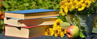 pic of books, table, apple, and flowers