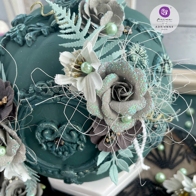 Dark green altered pumpkin with a dark academia aesthetic using moulds, flowers, pearls and gems from Prima Marketing Inc. (Lost in Wonderland, Twilight and The Plant Department Collections); Frank Garcia Memory Hardware; and Finnabair moulds, paint and wax.