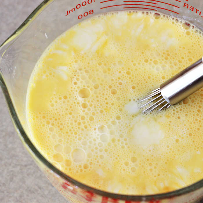 Egg mixture with whisk for ham egg and cheese casserole